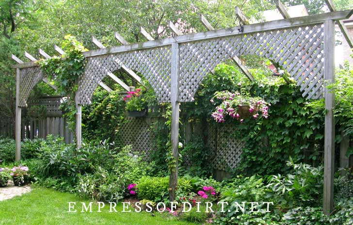 Lattice fence extension for privacy with colorful flower baskets. 